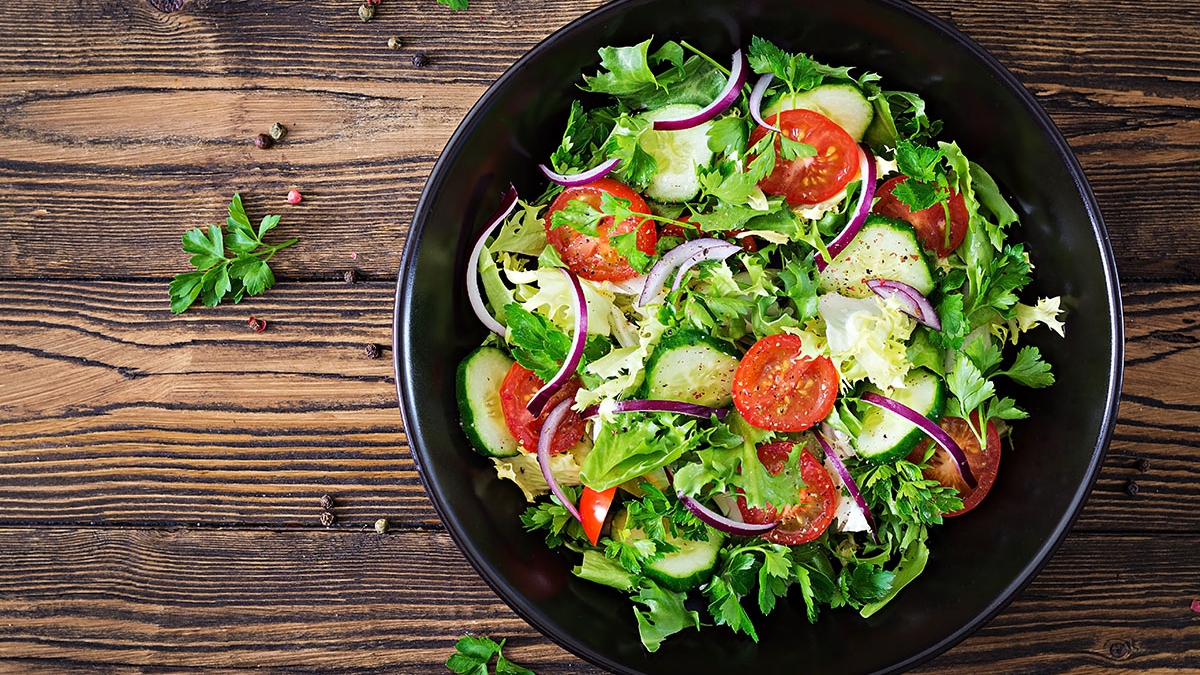 Salad from tomatoes, cucumber, red onions and lettuce leaves. He