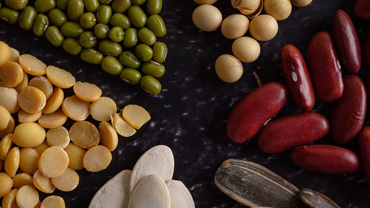 Legumes arranged in a circle on the black cement floor.