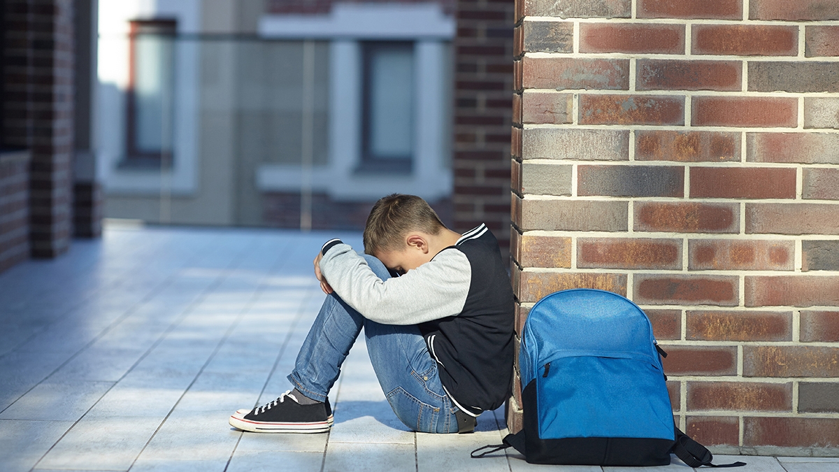 schoolboy crying in the hallway of the school