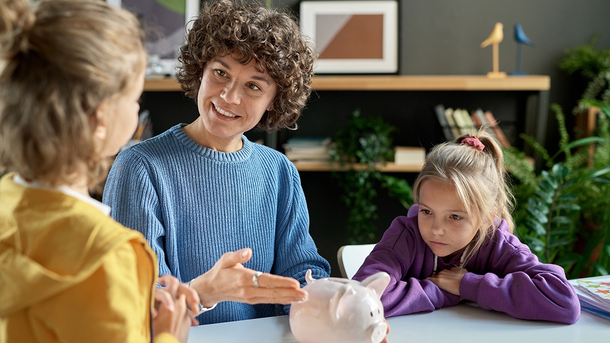 Mother teaching her children to save money